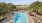 a pool surrounded by lounge chairs and trees