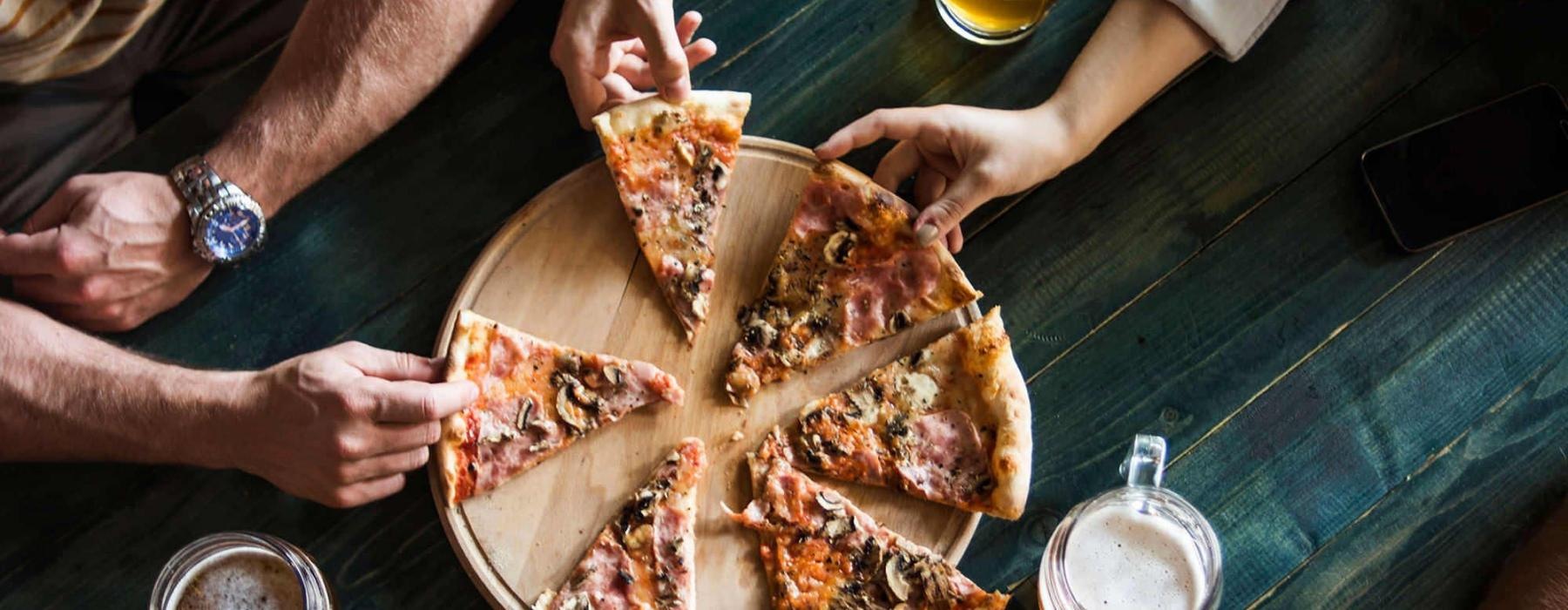 a group of people eating pizza