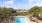 a pool surrounded by trees and buildings
